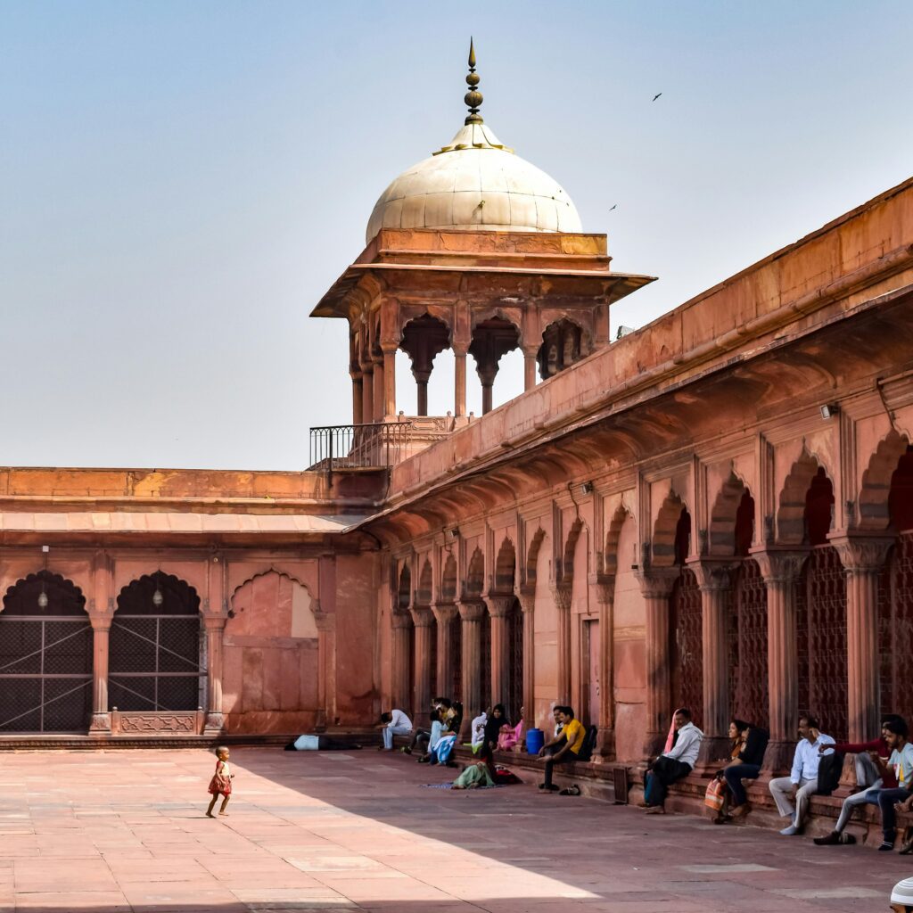 A tranquil scene of people sitting in the Jama Masjid courtyard, Delhi, India.