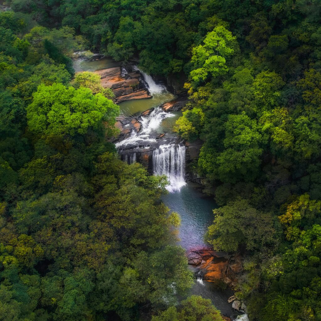 Stunning aerial view of lush waterfalls surrounded by forest in Matale, Sri Lanka.