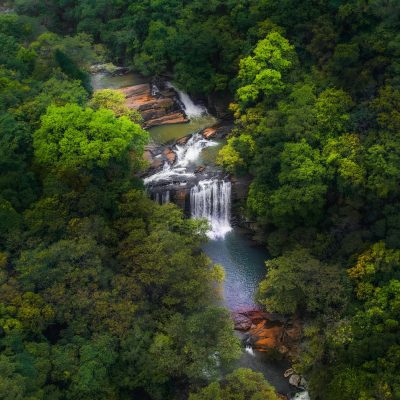 Stunning aerial view of lush waterfalls surrounded by forest in Matale, Sri Lanka.